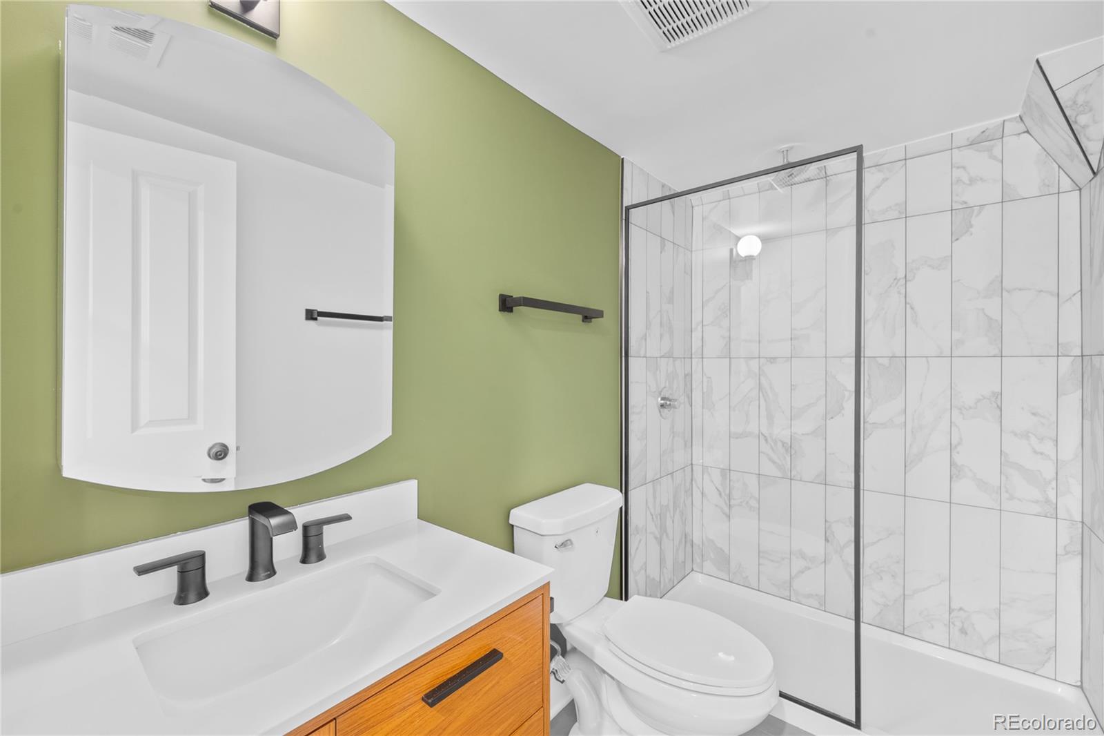 1442-1444 Stuart Street Denver, CO 80204 - Photo 23 of 26 a bathroom with a sink a toilet and shower