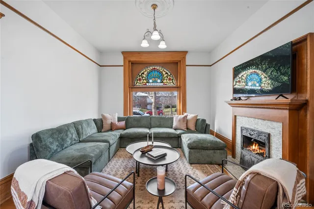 a living room with furniture a flat screen tv and a fireplace