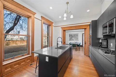 a large kitchen with kitchen island a large window cabinets and stainless steel appliances