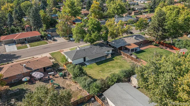 an aerial view of residential houses with outdoor space and trees