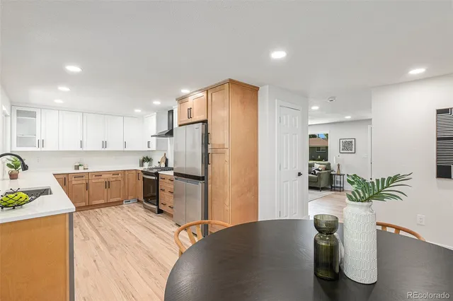 a kitchen with a refrigerator and a wooden floor