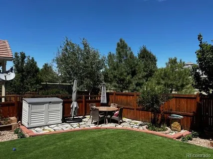 a view of a backyard with chairs and a grill