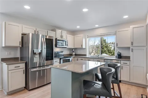 a kitchen with kitchen island a refrigerator stove microwave and cabinets