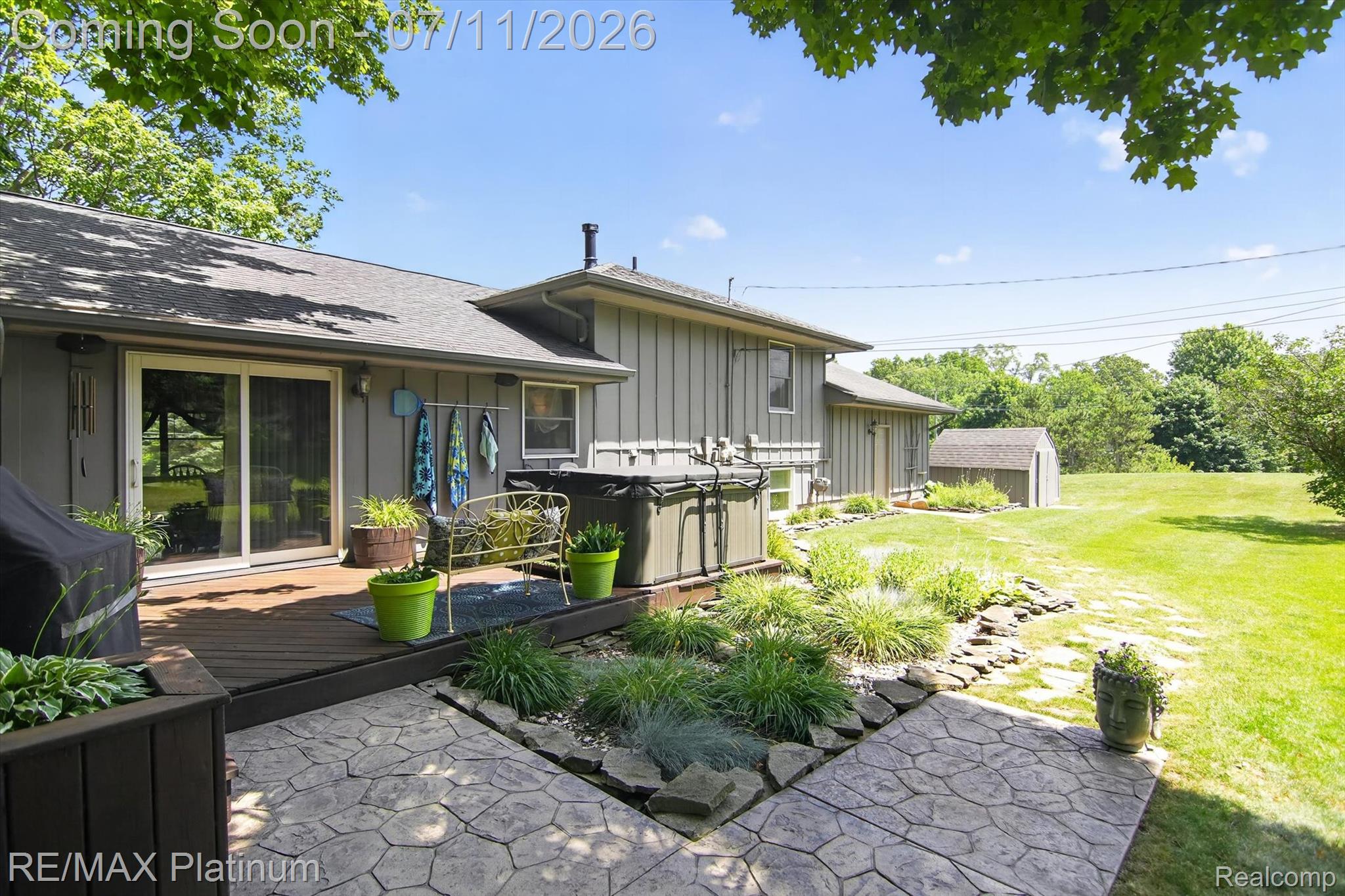 13365 North Territorial Road Gregory, MI 48137 - Photo 45 of 52 Expansive backyard featuring a stamped concrete patio, a wooden deck, and a hot tub