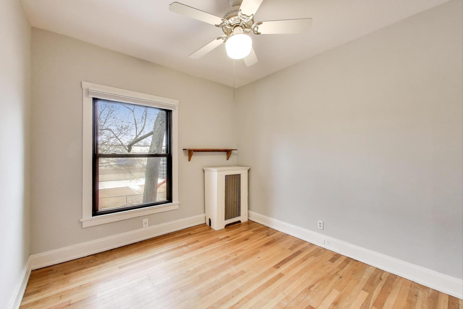 847 Judson Avenue, Unit 2 Evanston, IL 60202 - Photo 14 of 19 an empty room with wooden floor chandelier fan and windows