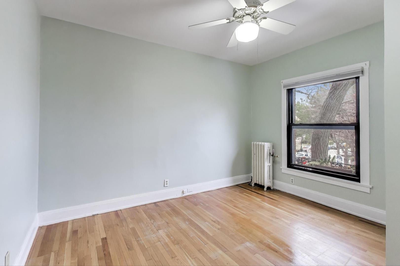 847 Judson Avenue, Unit 2 Evanston, IL 60202 - Photo 16 of 19 an empty room with wooden floor chandelier and windows