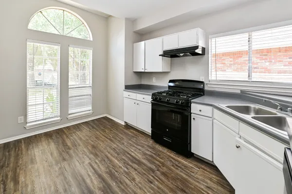a kitchen with a stove a sink and a window
