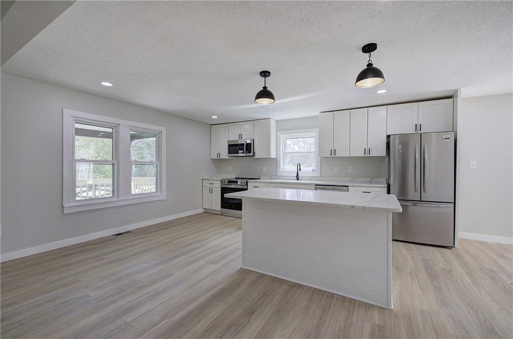 4604 Highway 151 LaFayette, GA 30728 - Photo 2 of 30 a kitchen with stainless steel appliances granite countertop a refrigerator a sink dishwasher a stove and white countertops with wooden floor
