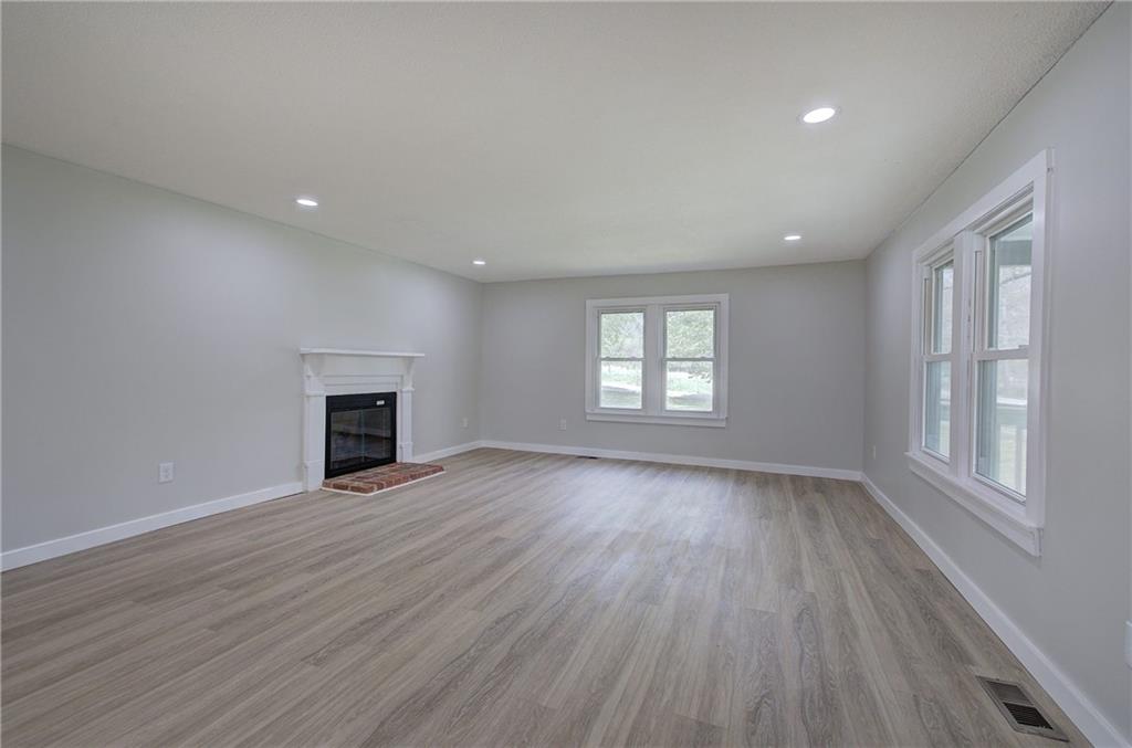 4604 Highway 151 LaFayette, GA 30728 - Photo 5 of 30 an empty room with wooden floor fireplace and windows