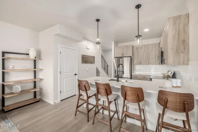 a view of a living room with furniture and a refrigerator