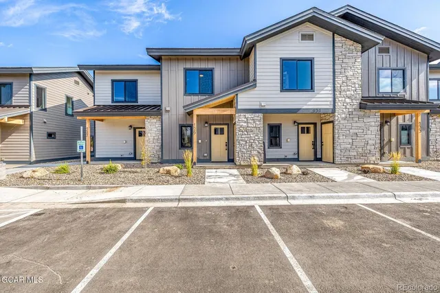 a front view of a house with a garden and garage