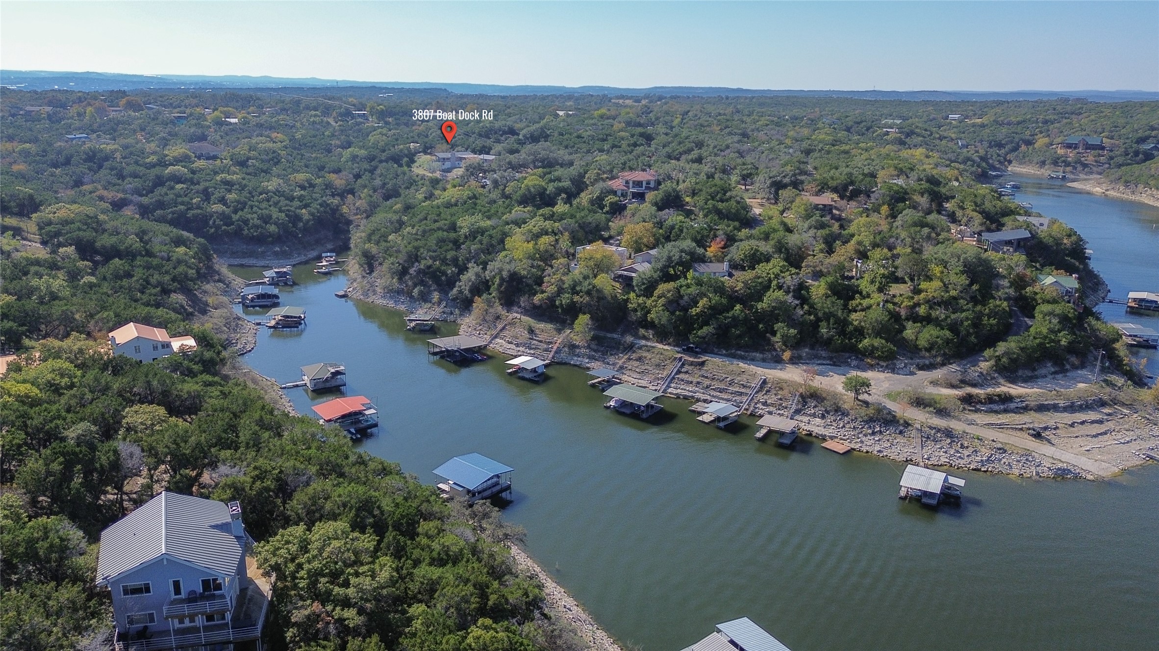 3807 Boat Dock Road Lago Vista, TX 78645 - Photo 30 of 37 An aerial perspective reveals numerous boat docks lining the scenic waterfront, nestled amongst lush, mature trees.