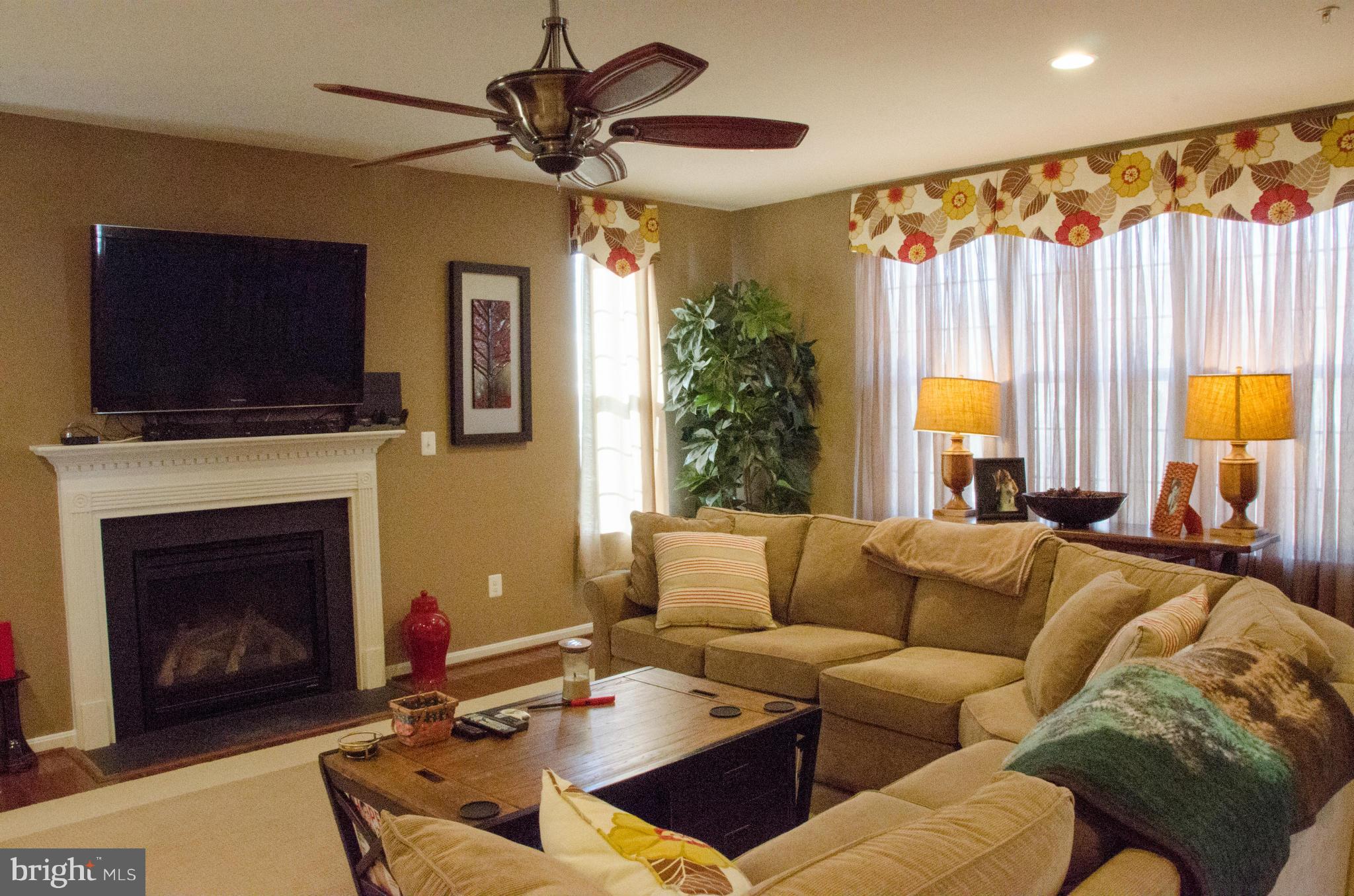 826 Salvatore Road Baltimore, MD 21220 - Photo 7 of 30 a living room with furniture a flat screen tv and a fireplace