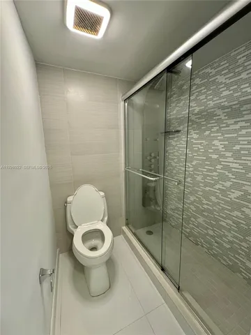 a bathroom with a toilet and a shower