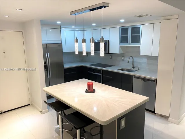 a kitchen with a table chairs refrigerator and microwave