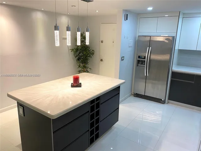 a kitchen with a refrigerator sink and cabinets