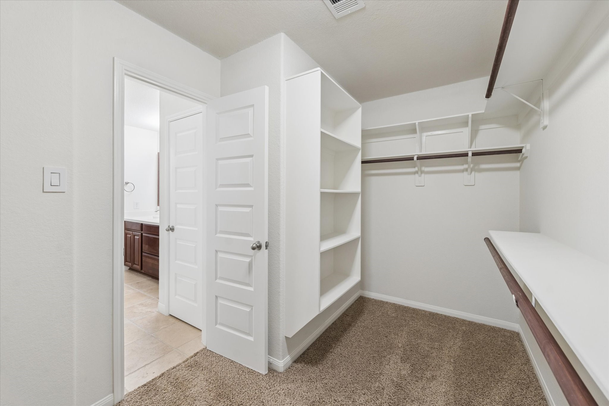 7015 Riata Hills Lane Spring, TX 77379 - Photo 19 of 33 The primary suite includes a spacious walk-in closet with built-in shelving for optimal organization, recently painted to offer a fresh and refined feel.