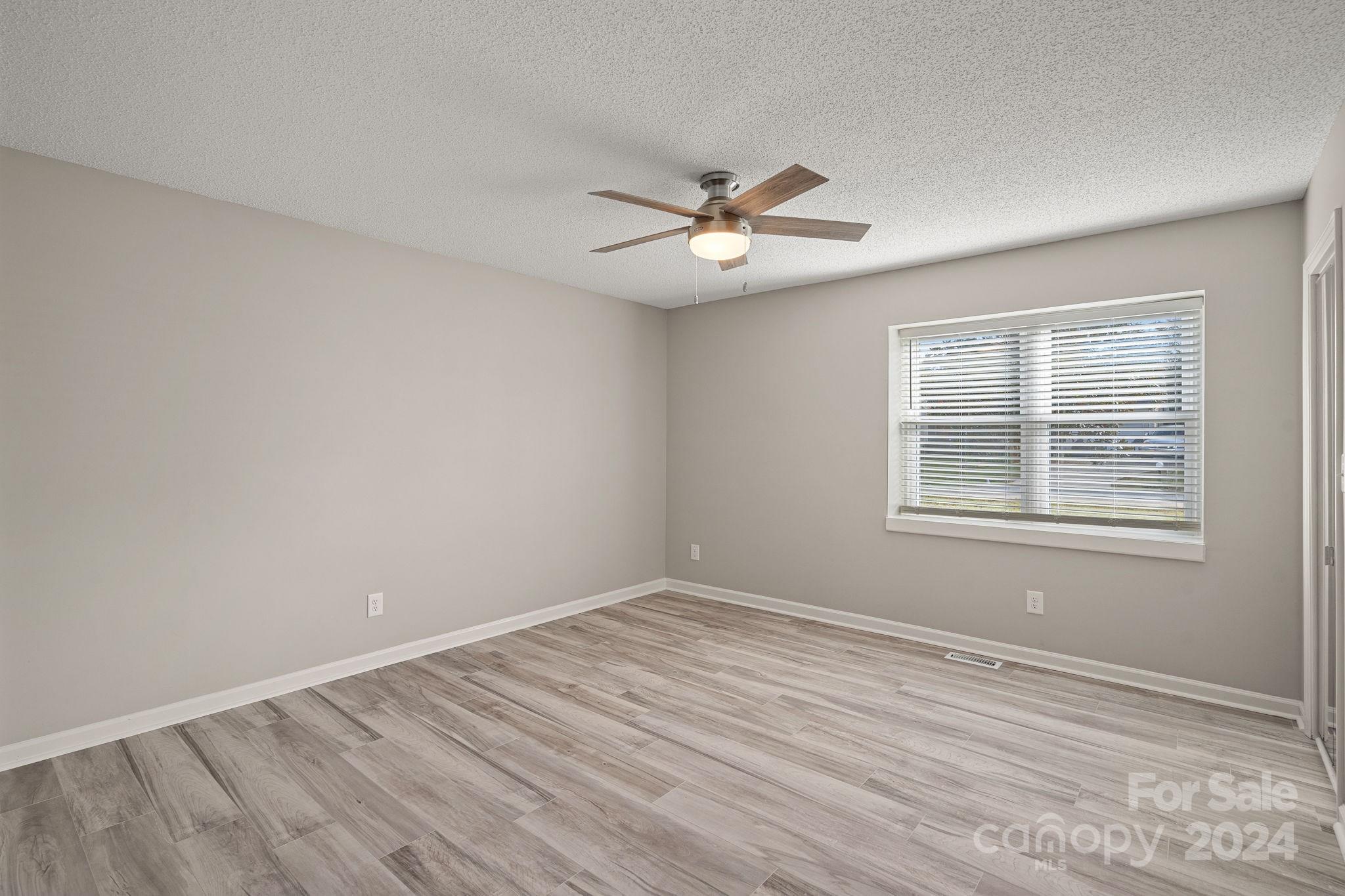 7505 Sarah Drive Denver, NC 28037 - Photo 17 of 34 a view of empty room with wooden floor and fan