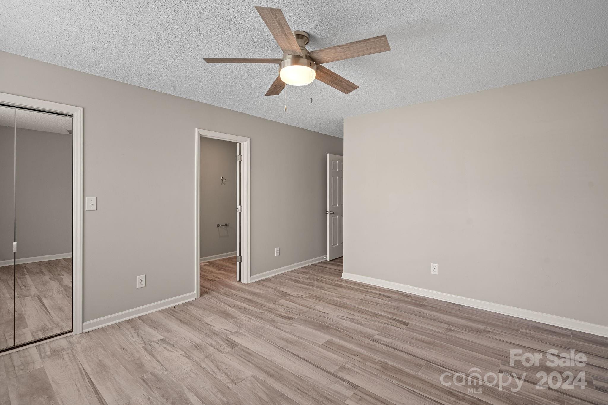 7505 Sarah Drive Denver, NC 28037 - Photo 18 of 34 an empty room with wooden floor and a ceiling fan