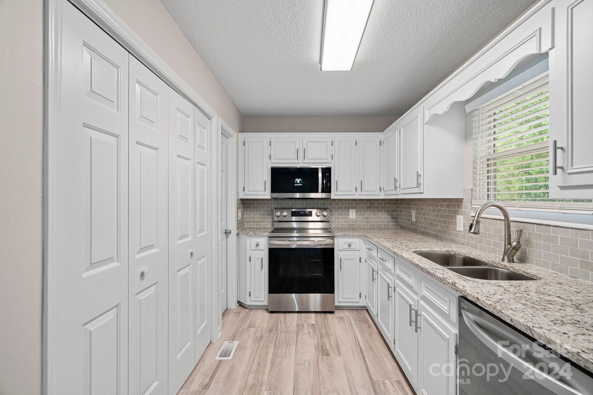 7505 Sarah Drive Denver, NC 28037 - Photo 8 of 34 a kitchen with a sink stove and cabinets