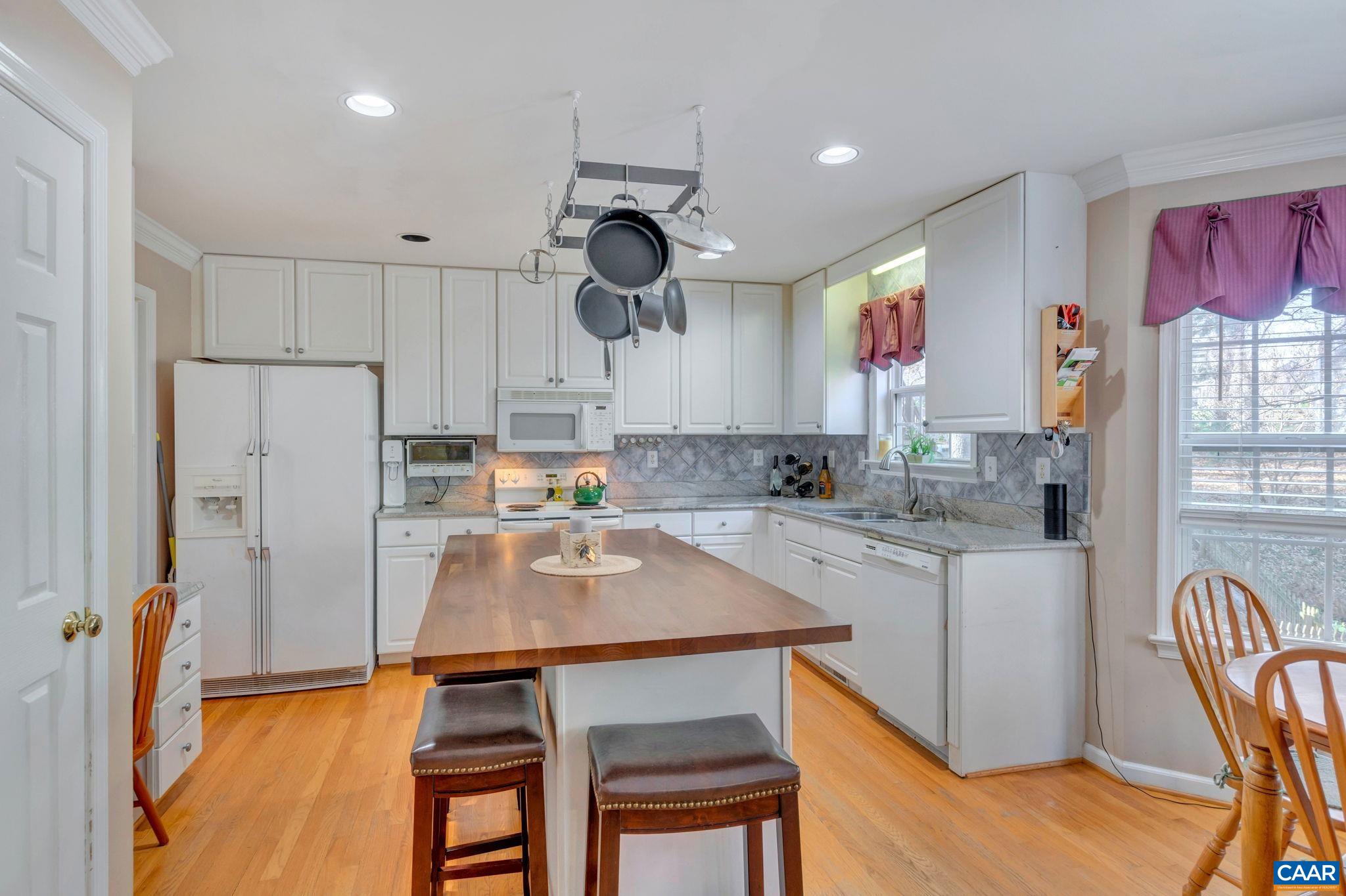 1642 Old Brook Road Charlottesville, VA 22901 - Photo 12 of 42 a kitchen with granite countertop a table chairs microwave and cabinets