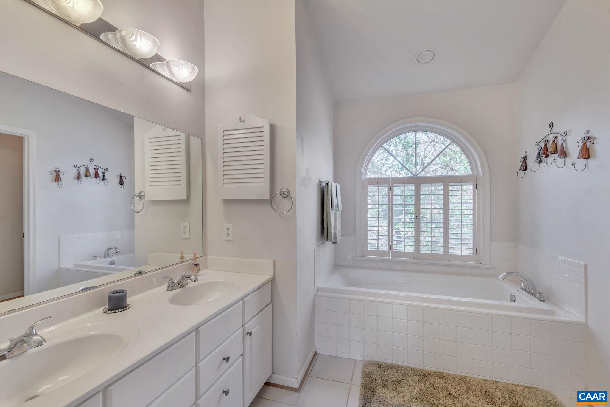 1642 Old Brook Road Charlottesville, VA 22901 - Photo 24 of 42 a bathroom with a granite countertop sink a large mirror a bathtub and next to a window