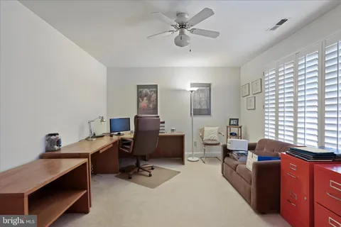 a view of a livingroom with workspace and a window