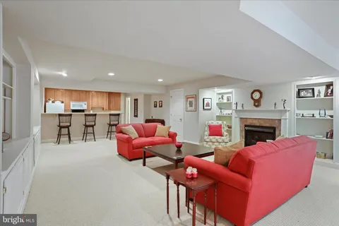 a living room with furniture a fireplace and kitchen view