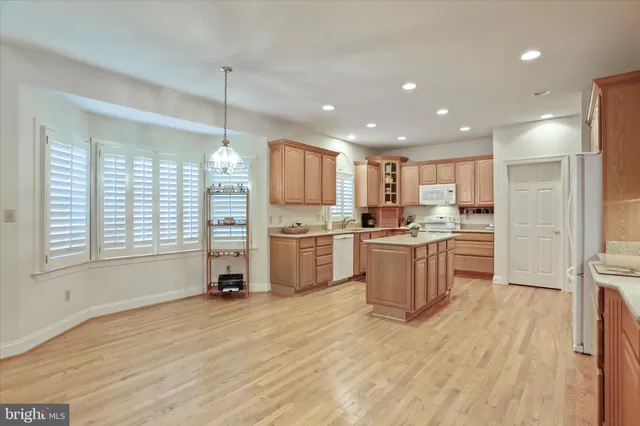 a kitchen with a refrigerator a oven and a sink with wooden floor