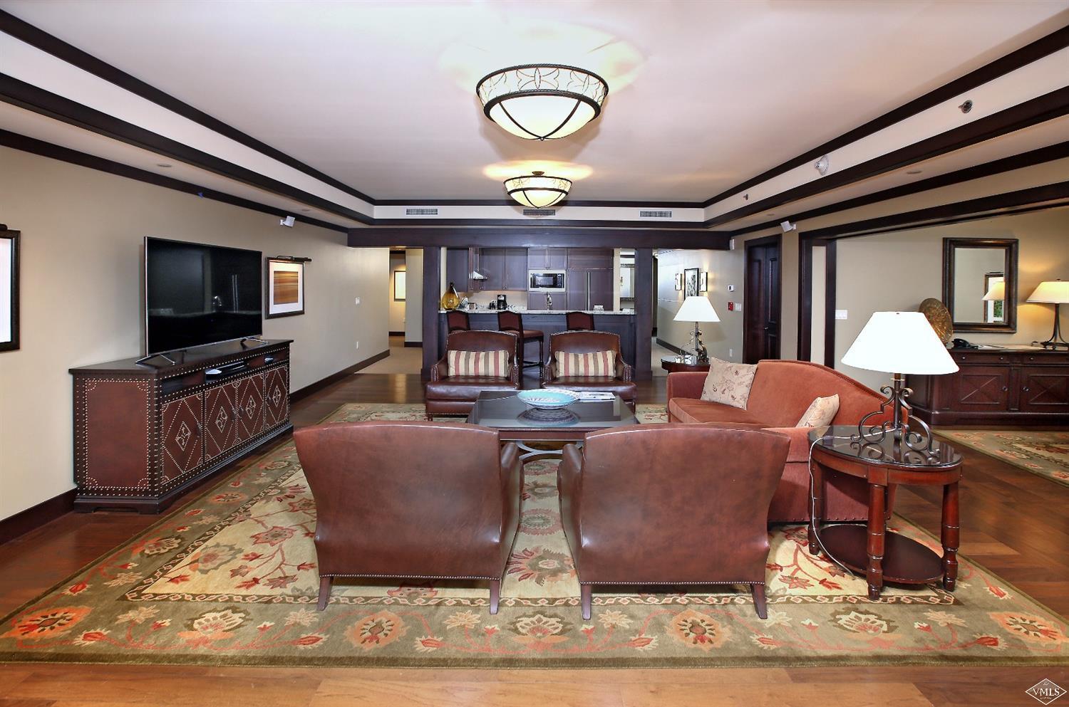 1 Vail Road, Unit 4103 Vail, CO 81657 - Photo 5 of 19 a living room with furniture a flat screen tv and kitchen view