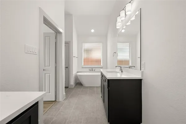 a bathroom with a bathtub sink and mirror