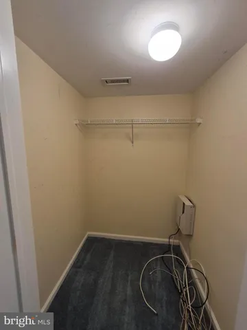 a view of a white house with large windows and a table and chairs in a yard