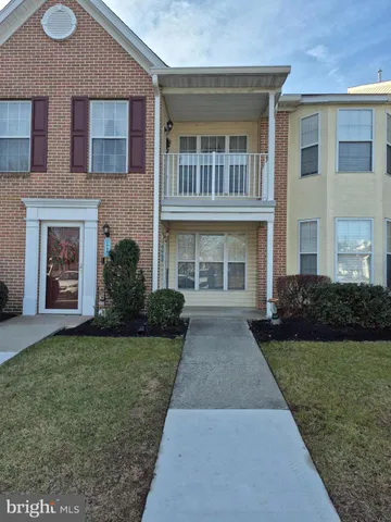 front view of a brick house with a yard