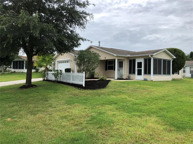 a front view of a house with a garden and trees