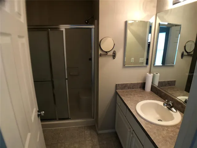 a bathroom with a sink vanity granite and a mirror