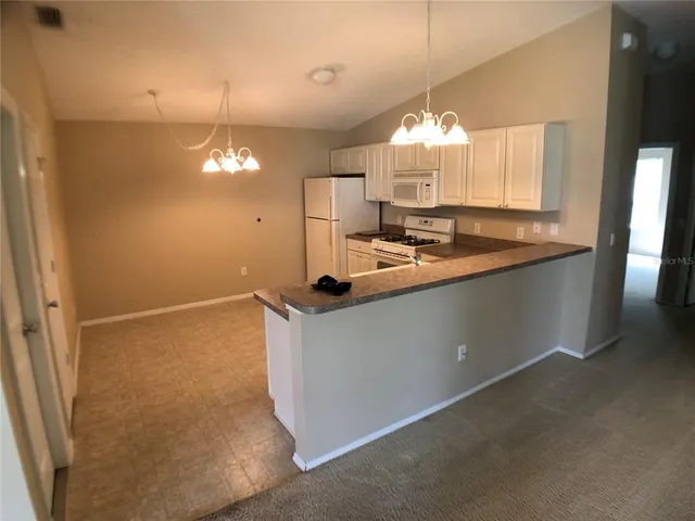 a view of a kitchen counter space a sink and chandelier