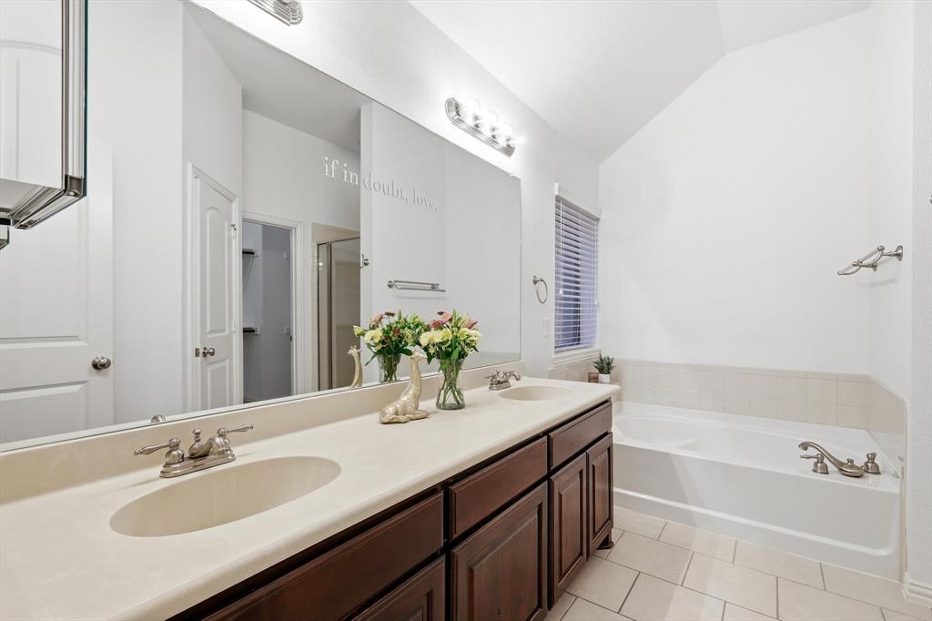 3818 Downing Drive Midlothian, TX 76065 - Photo 13 of 32 Bathroom with lofted ceiling, double vanity, a bath, light tile patterned flooring, and a shower stall