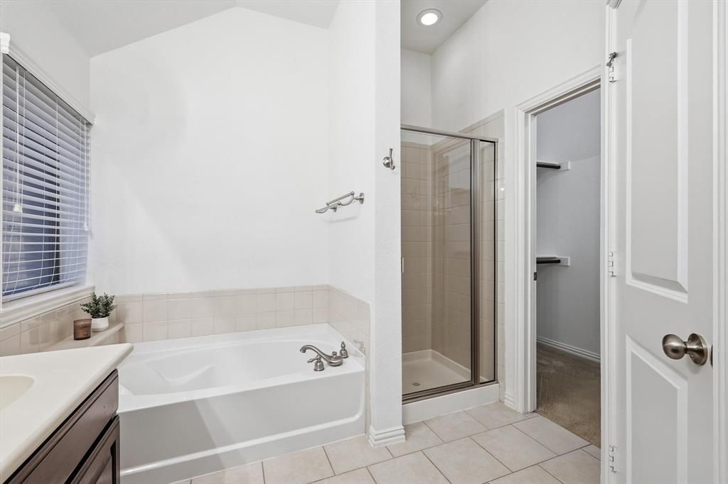3818 Downing Drive Midlothian, TX 76065 - Photo 14 of 32 Full bath featuring vanity, a bath, a shower stall, light tile patterned floors, and vaulted ceiling