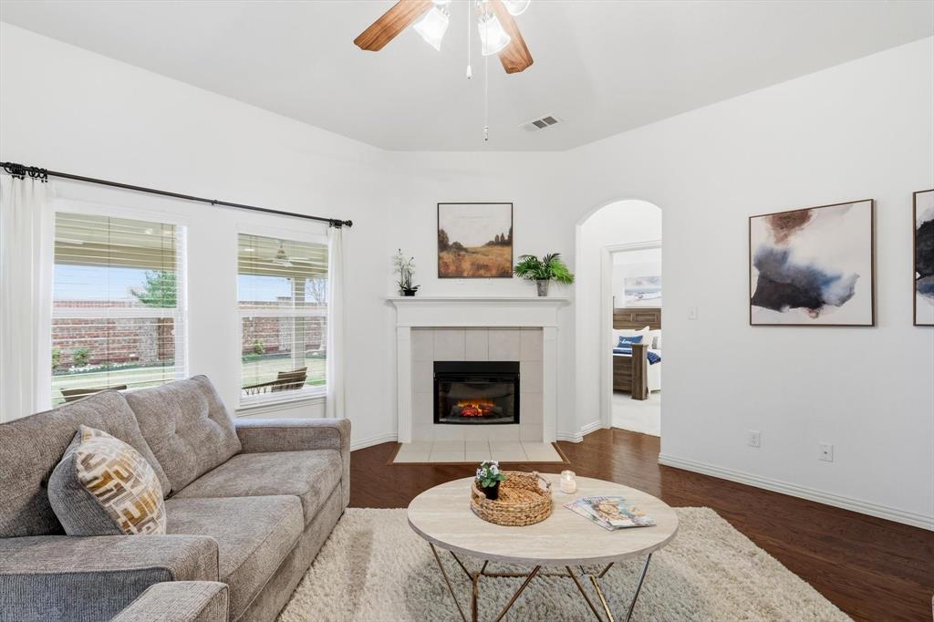 3818 Downing Drive Midlothian, TX 76065 - Photo 4 of 32 Living room with ceiling fan, dark wood-style floors, arched walkways, and a tile fireplace