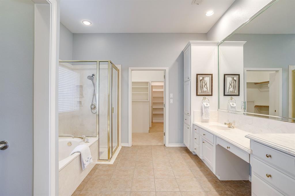 8700 Bellechase Road Granbury, TX 76049 - Photo 18 of 30 a large en suite bathroom with a double vanity sink a large mirror and a bathtub