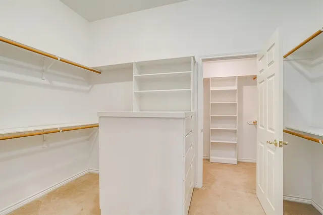 a view of walk in closet with empty racks