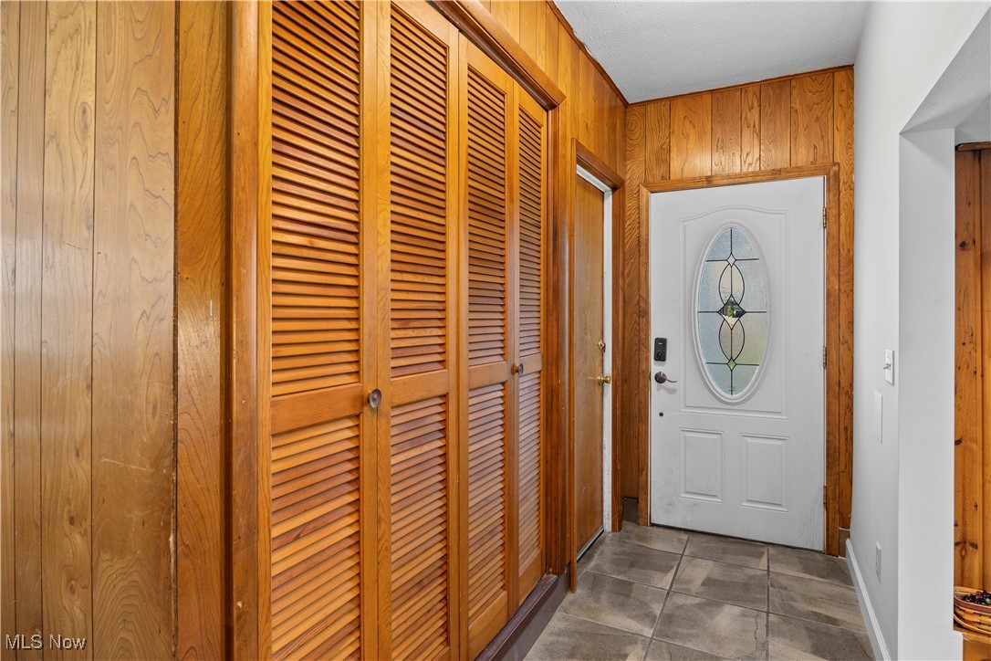 958 West River Road Vermilion, OH 44089 - Photo 5 of 40 Doorway with dark tile patterned floors and wooden walls