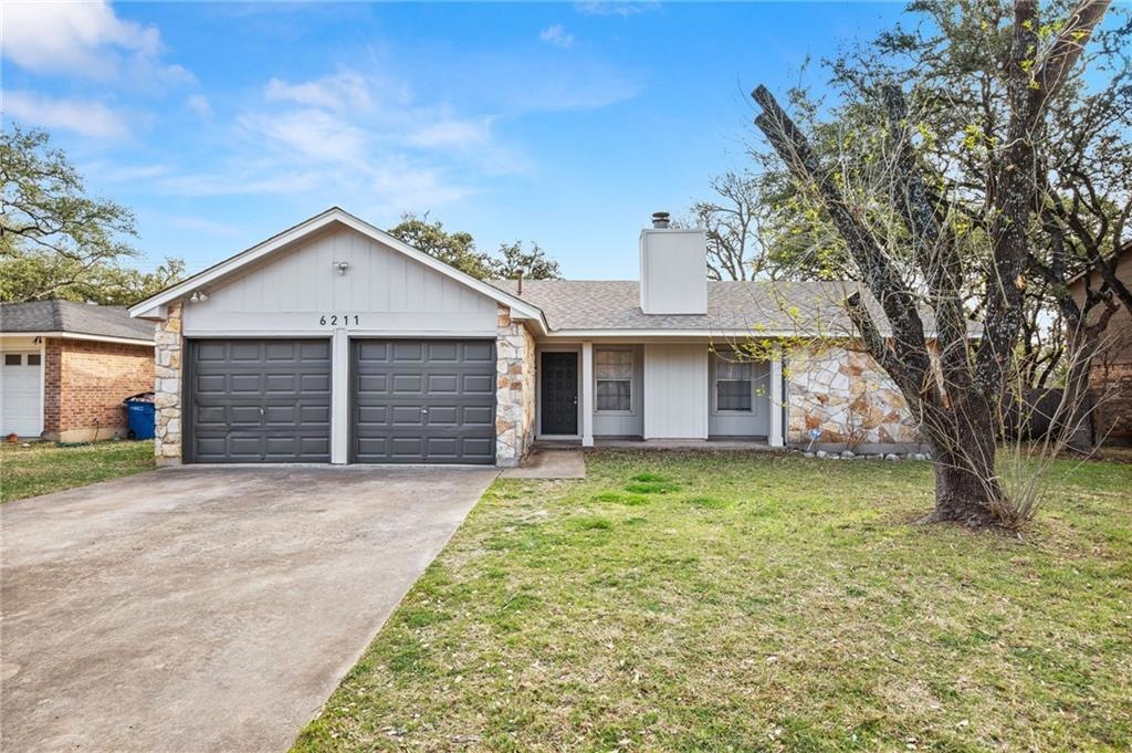 Single-story residence featuring a two-car garage with dark paneled doors