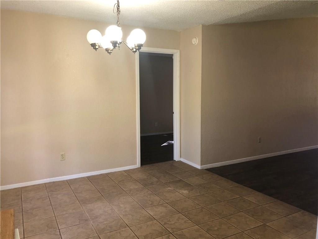 6211 Sunkist Lane Austin, TX 78749 - Photo 3 of 8 Interior space featuring neutral tone walls, a ceiling-mounted chandelier with three globe lights, and a white trim doorway