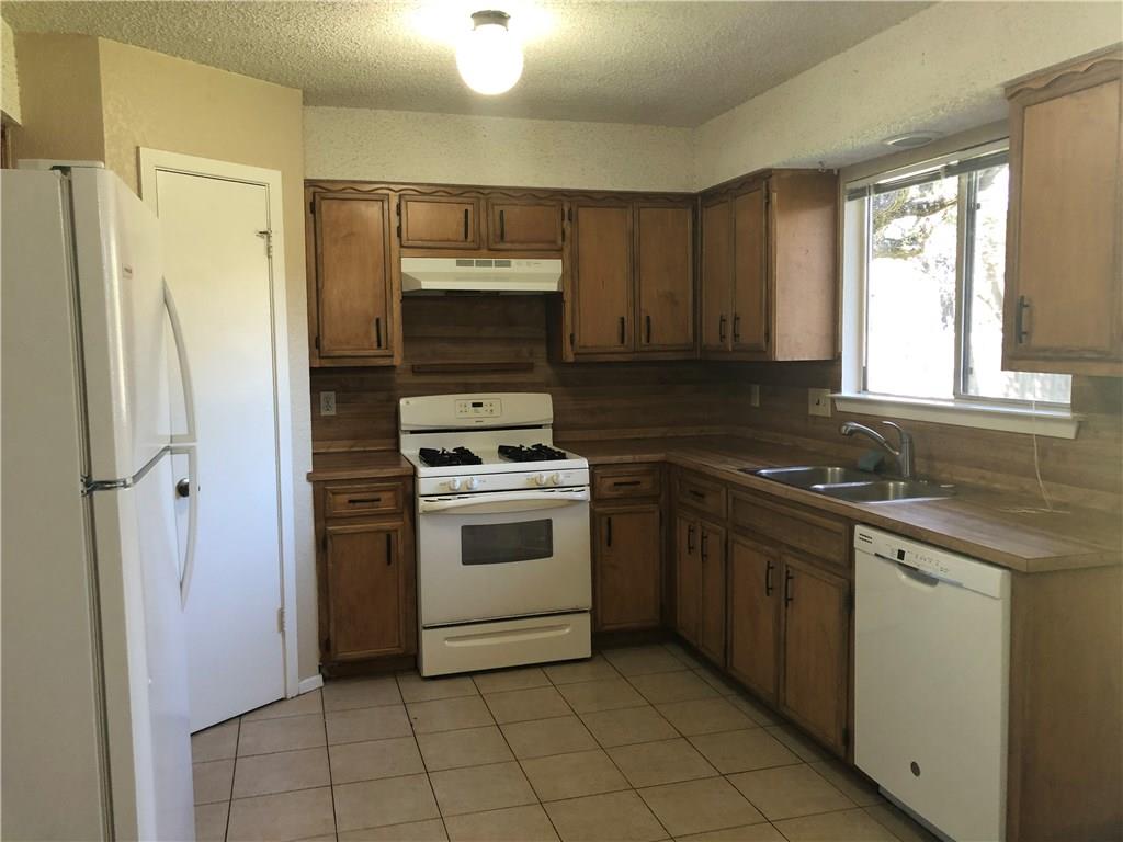 6211 Sunkist Lane Austin, TX 78749 - Photo 4 of 8 Kitchen featuring wood-finish cabinetry, tile flooring, and integrated window
