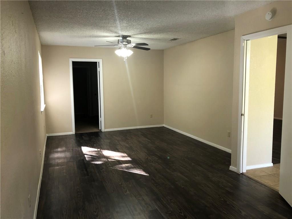6211 Sunkist Lane Austin, TX 78749 - Photo 6 of 8 Spacious interior room featuring wood-finish flooring, neutral wall tones, and a ceiling fan with integrated lighting