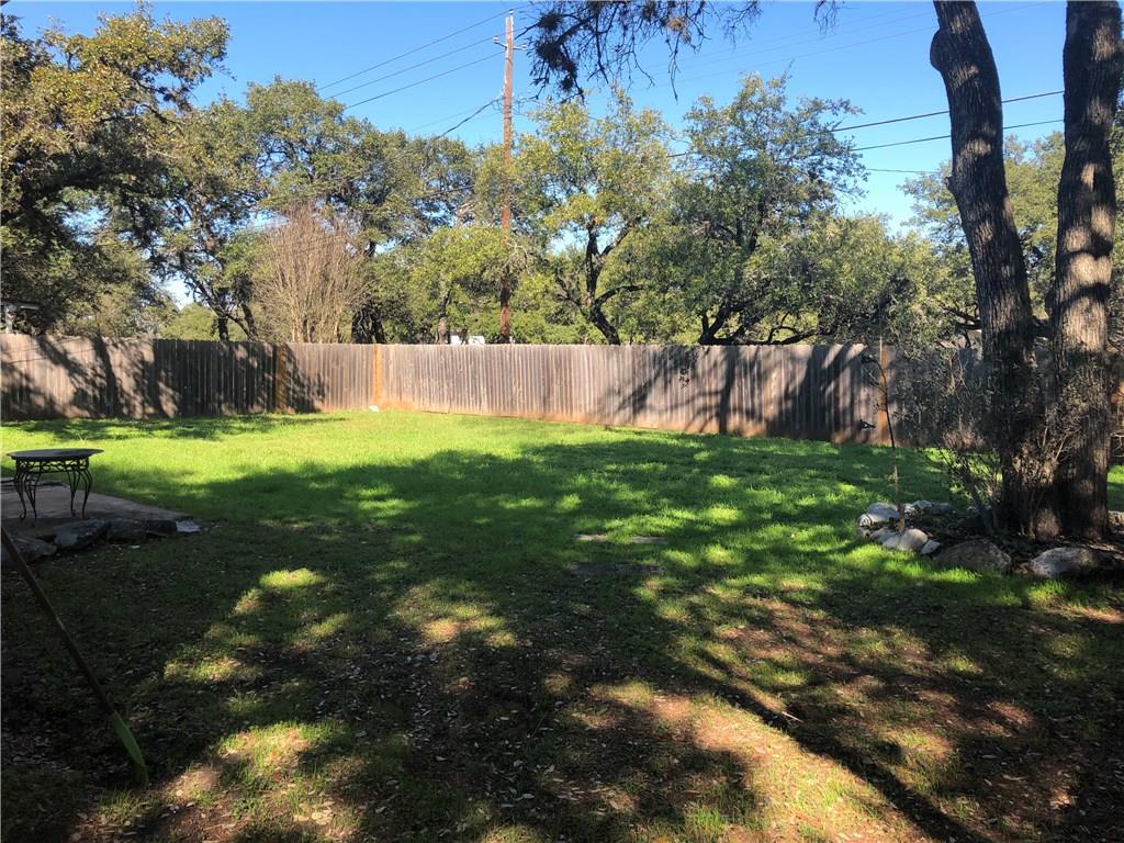 6211 Sunkist Lane Austin, TX 78749 - Photo 7 of 8 Expansive backyard featuring a wood privacy fence, mature trees, and a grassy lawn