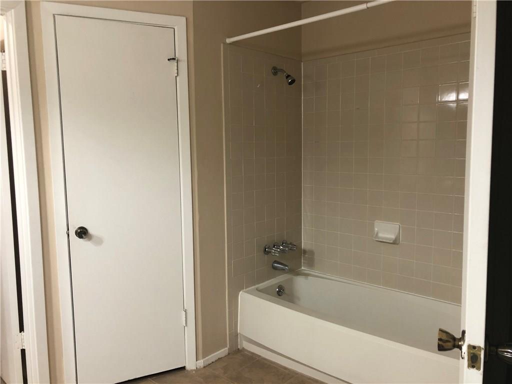 6211 Sunkist Lane Austin, TX 78749 - Photo 8 of 8 Bathroom featuring a white bathtub with chrome fixtures, beige wall tile, and a shower curtain rod