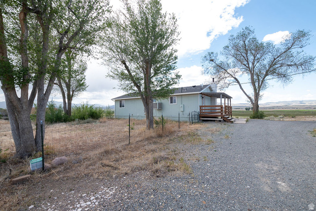 570 West Main Street Beaver, UT 84713 - Photo 37 of 43 Single-story residence featuring a light-colored exterior siding, a covered wood-finish porch, and a gravel driveway