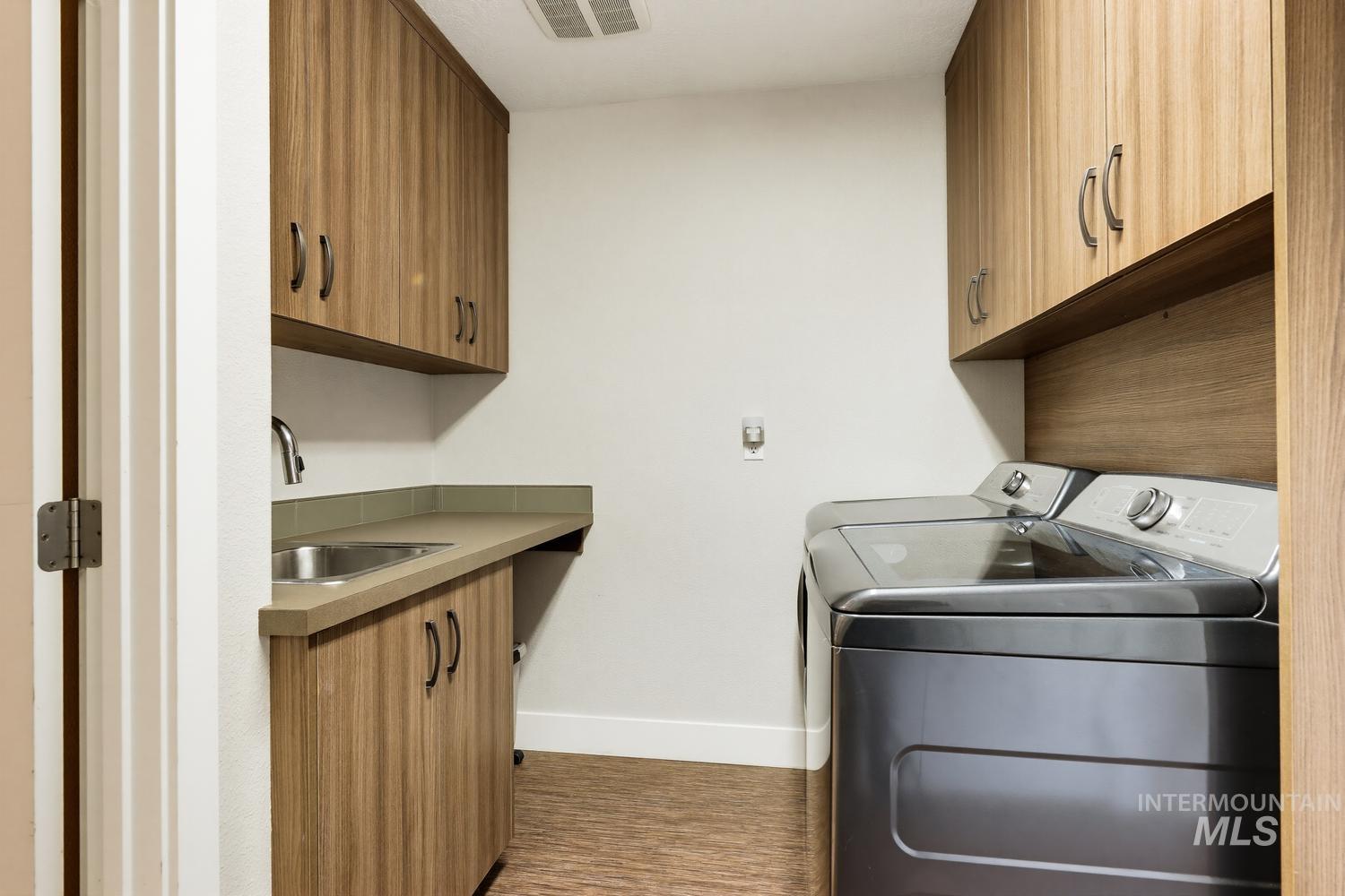 369 South Winthrop Way Boise, ID 83709 - Photo 37 of 50 Dedicated laundry area featuring wood-finish cabinetry, a utility sink with a chrome faucet, and ample countertop space